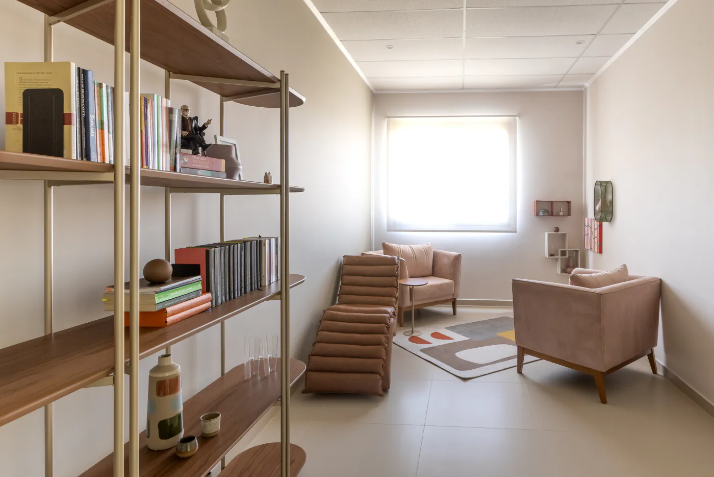 Sala de psicologia do LYRATA com poltronas, chaise e estante de livros